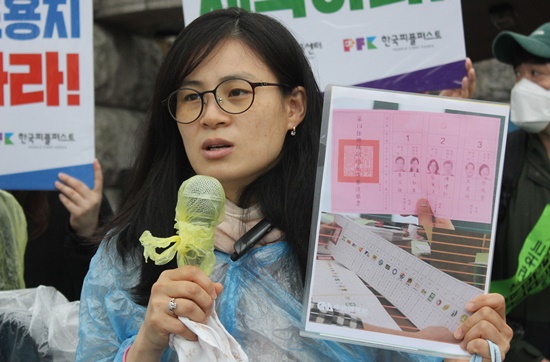 후보자의 사진과 정당 로고가 그려진 대만의 투표용지를 들고 발언 중인 장애인권법센터 김예원 변호사.ⓒ에이블뉴스