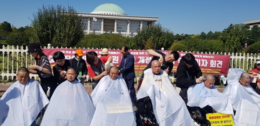 지난해 10월 8일 국회 앞에서 한국장애인자립생활총연맹 소속 중증장애인 6명이 삭발식을 진행 중이다.ⓒ에이블뉴스