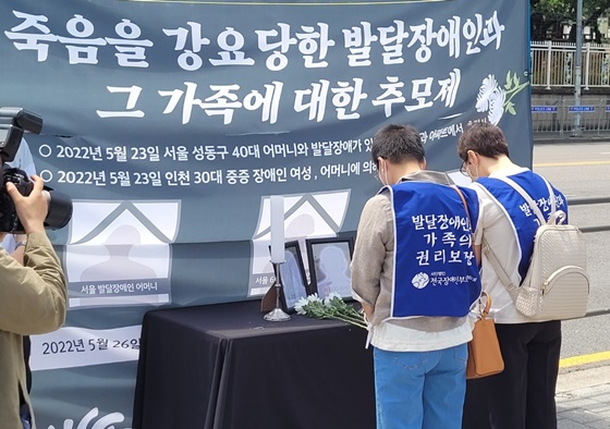 26일 오전 11시 서울 용와대 인근 전쟁기념관 6.25 상징탑 앞에서 열린 ‘발달장애인과 그 가족에 대한 추모제’에서 헌화하는 추모객들. ⓒ에이블뉴스